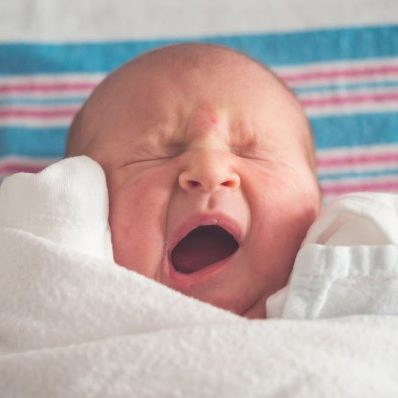 A baby sitting on a bed